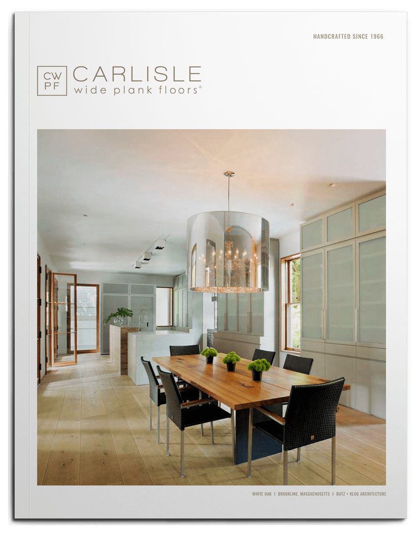 Dining table, chairs, and chandelier in a modern kitchen with wide plank flooring.
