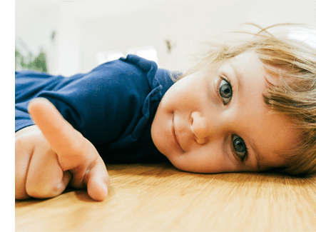 child on hardwood toddler laying on natural wood flooring