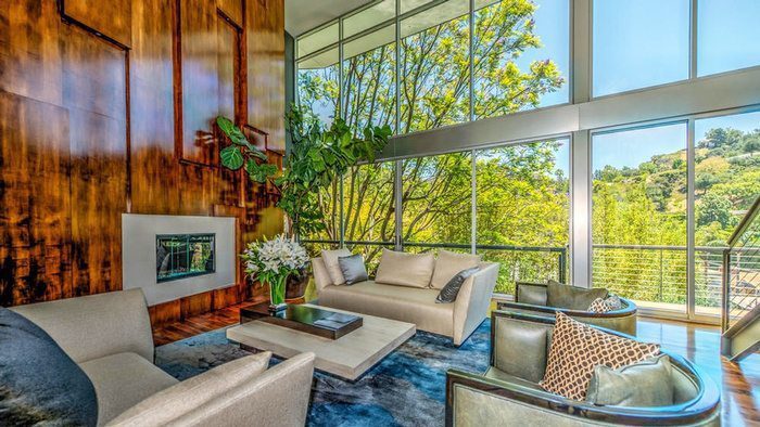 Dark wood paneling, next to a wall of windows in a contemporary living room