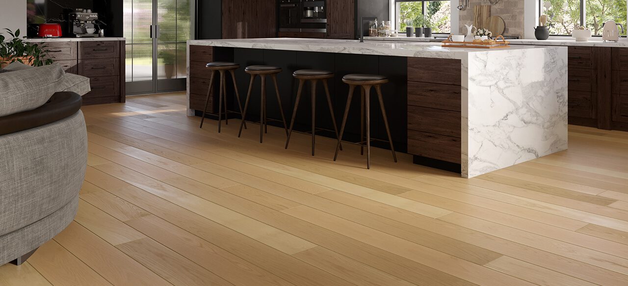Kitchen with stools along marble island and wide plank flooring.