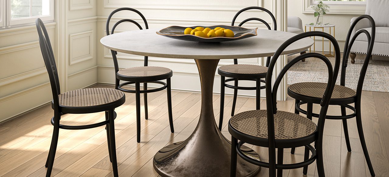 Round table with lemons, black chairs on wide plank flooring.