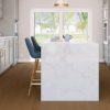 White marble island in modern kitchen with wide plank flooring and blue chairs.