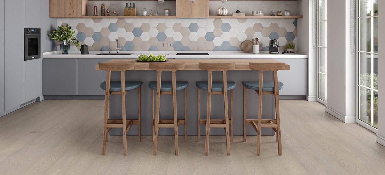 Wooden high table with chairs, wide plank flooring, hexagonal tile backsplash.